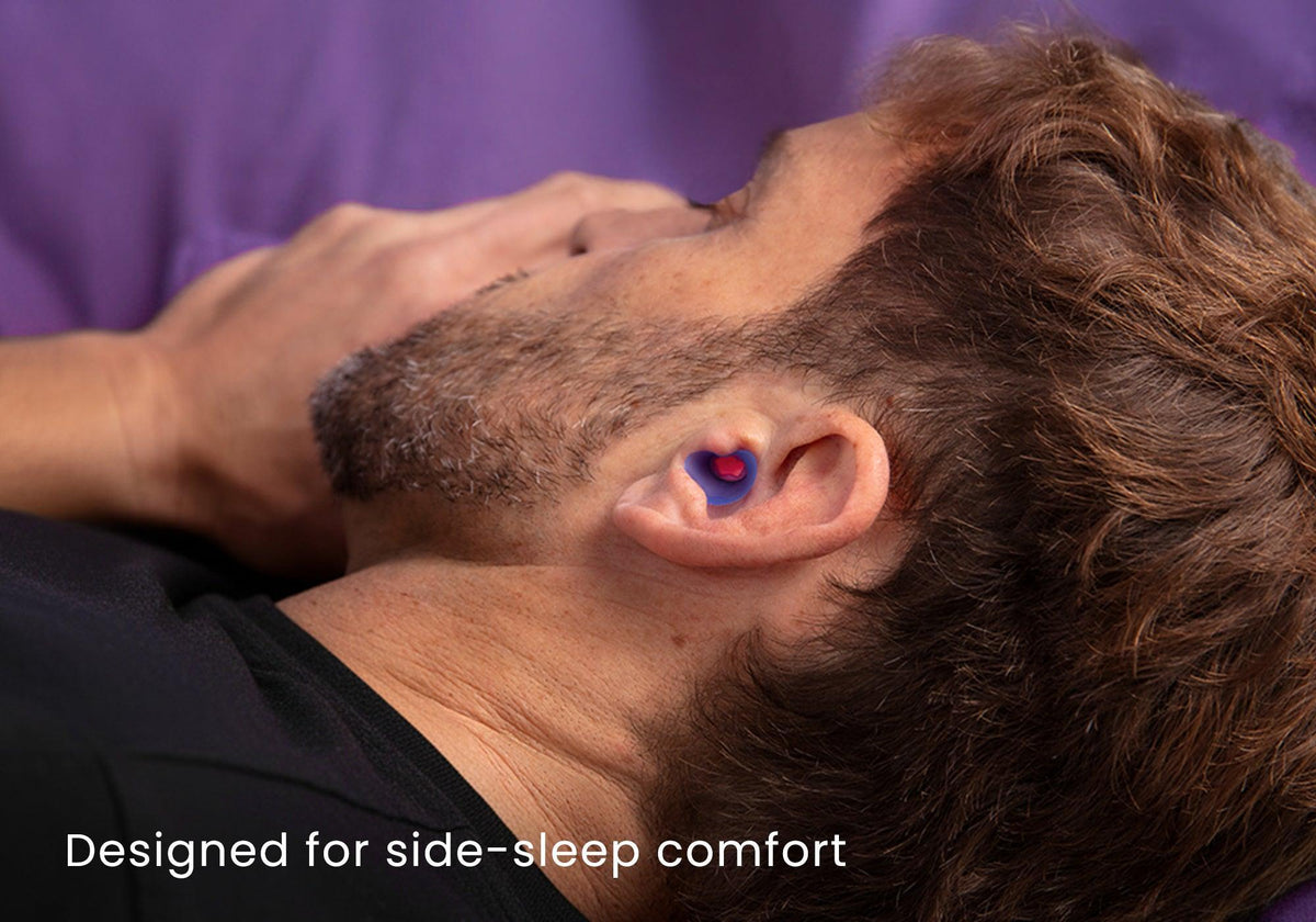 Close-up profile of a man lying down asleep while wearing a Manta Sleep earplug, captioned "Designed for side-sleep comfort".